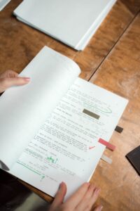 Páginas de roteiro com anotações sobre uma mesa de trabalho