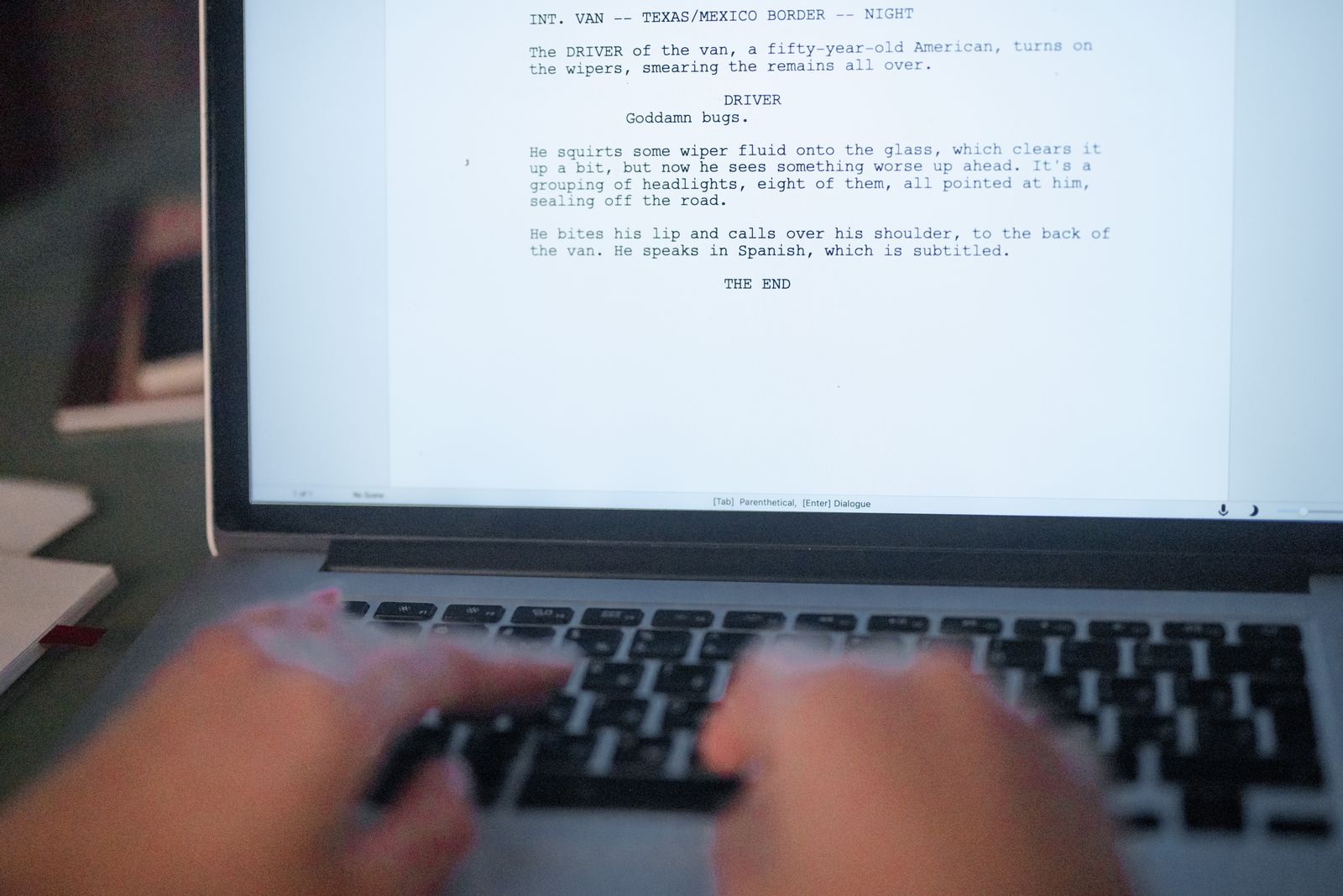 Roteiro audiovisual sendo digitado na tela de um laptop